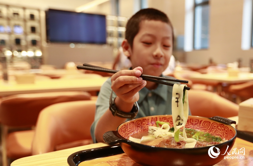 殷墟博物館推出的甲骨文面深受游客喜愛。人民網(wǎng)記者 慎志遠 攝